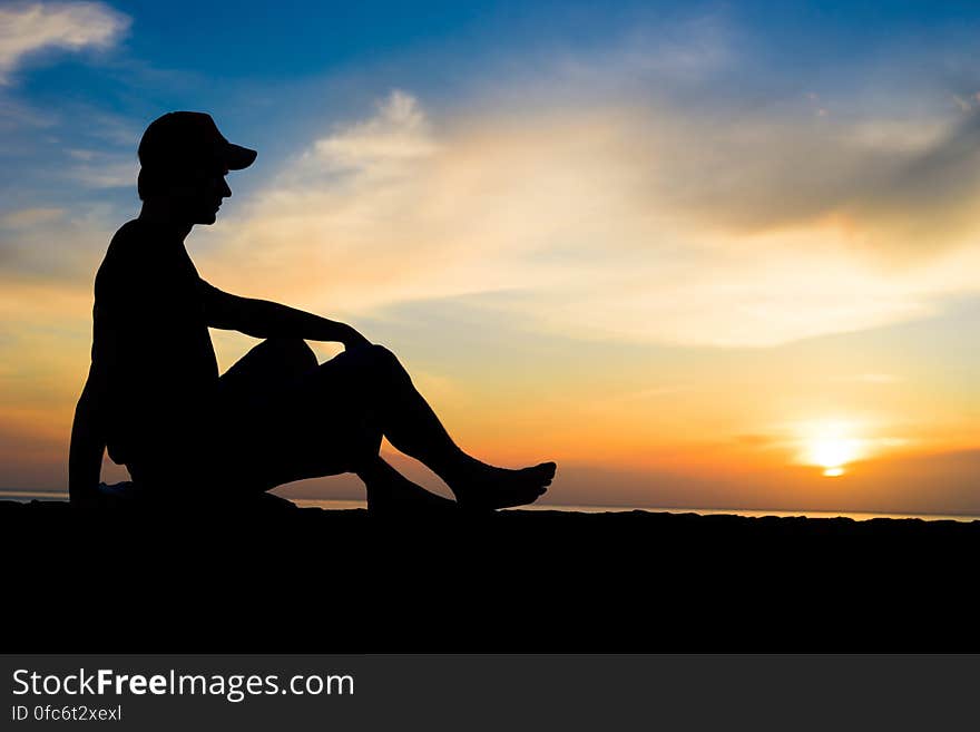 Silhouette of a man sitting near the ocean. Bali, Indonesia