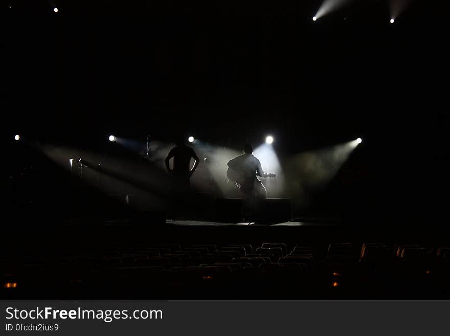 Band playing on stage in shadows with spotlights. Band playing on stage in shadows with spotlights.