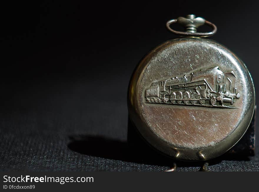 Close up of antique pocket watch with art work of train in metal.