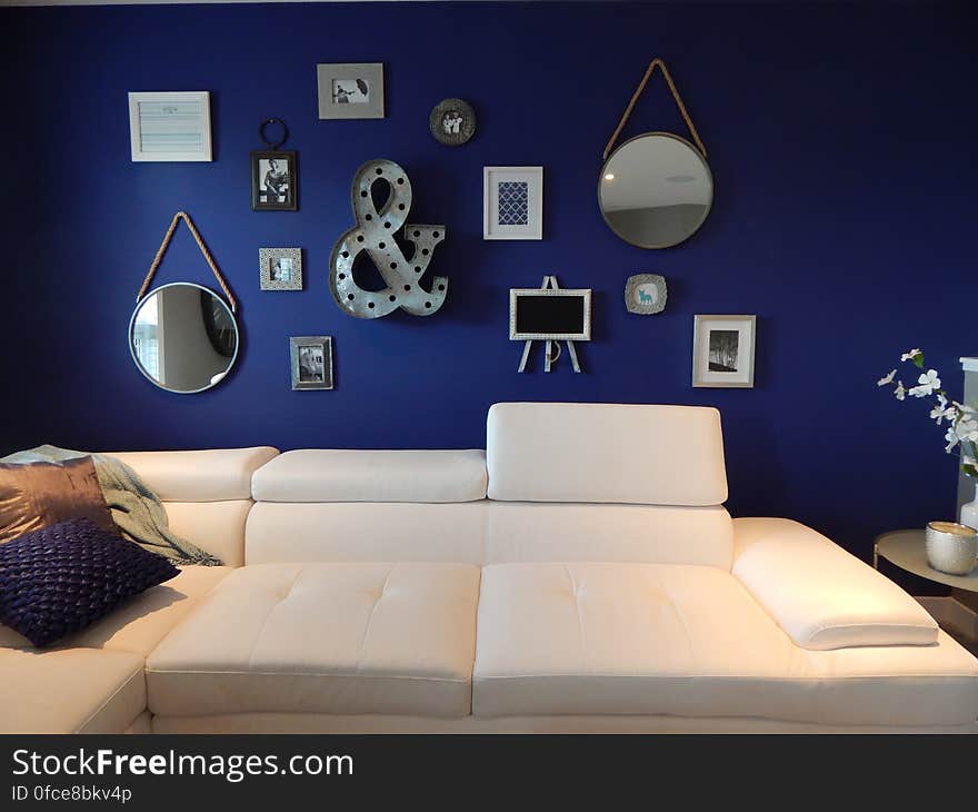 Interior of contemporary living room with modern art on blue wall and leather furnishings.