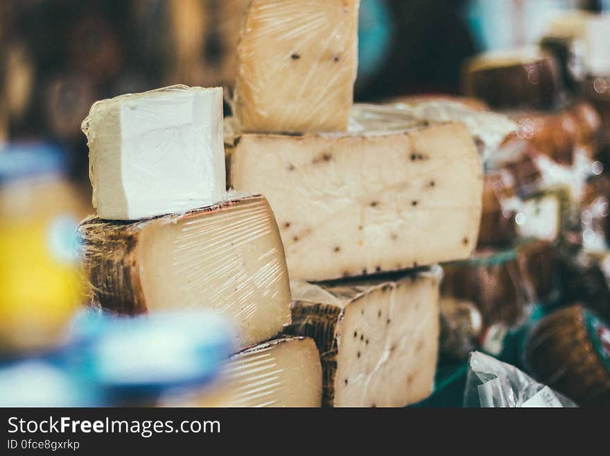 Stack of cheese wedges on display in market.