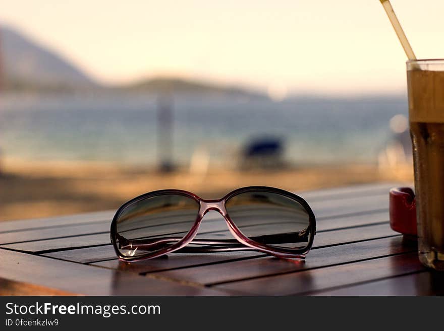 Pink Plastic Framed Wayfarer Sunglasses on Brown Table Top