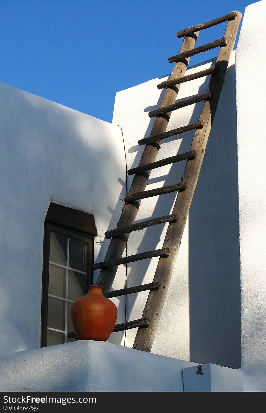 white adobe house with ladder