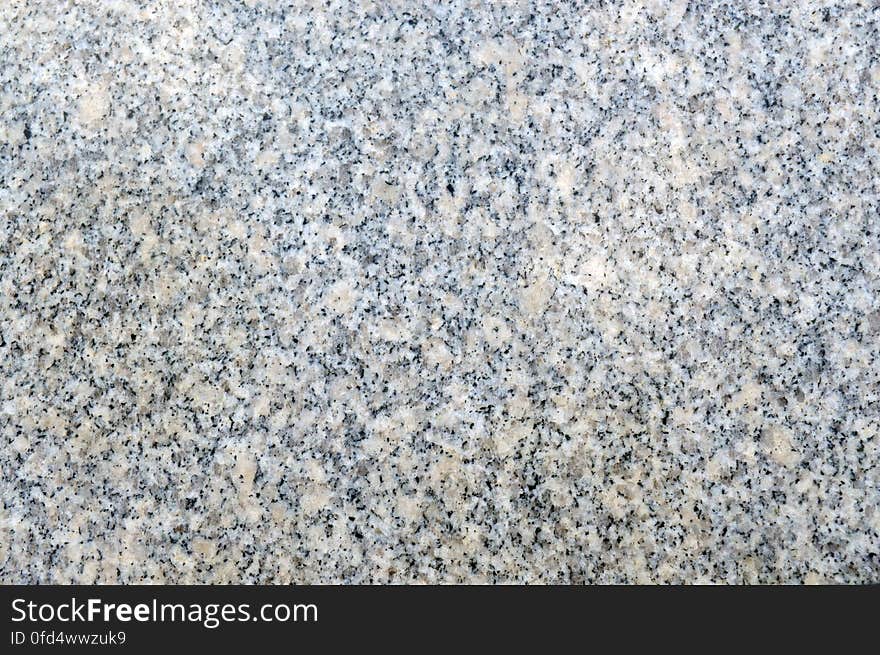 Texture of beige and grey natural granite with polished surface