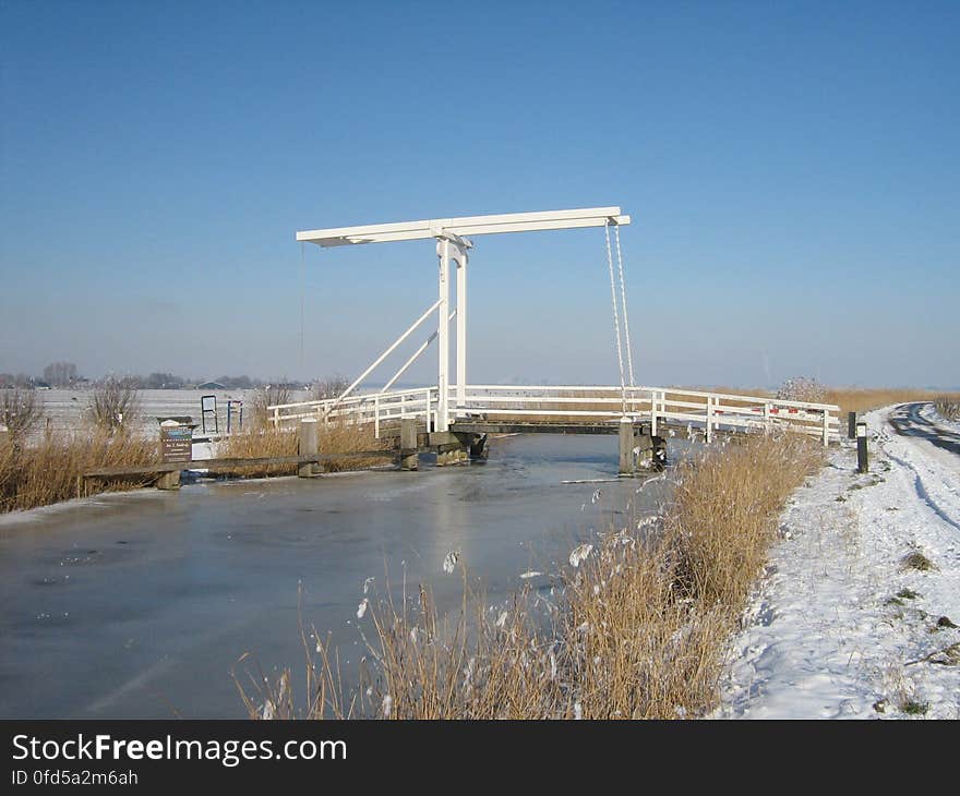 The &#x22;Jac. C. Keabrug&#x22;, a drawbridge crossing the River Waver, just east of the village of Nes aan de Amstel, the Netherlands. The bridge is seen from the southwest here. The &#x22;Jac. C. Keabrug&#x22;, a drawbridge crossing the River Waver, just east of the village of Nes aan de Amstel, the Netherlands. The bridge is seen from the southwest here.