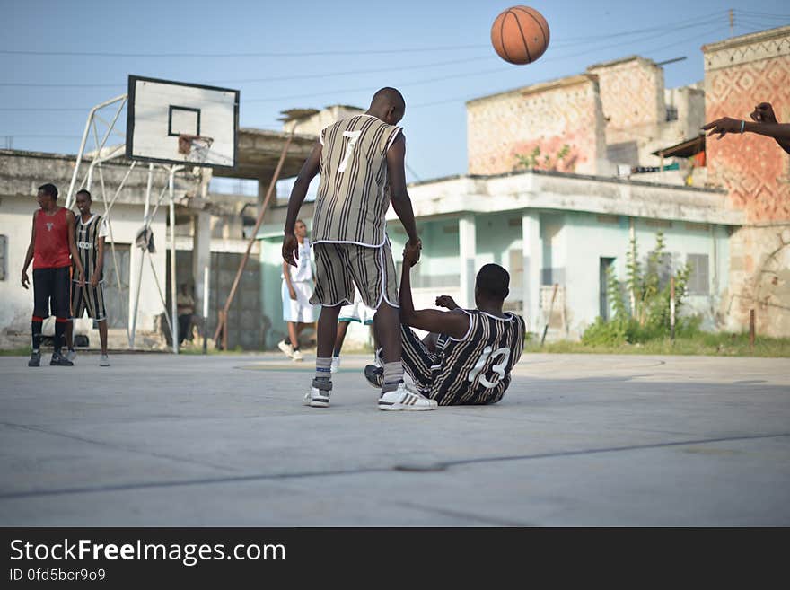 A player helps his teammate up during a basketball game in Mogadishu, Somalia, on June 6. Banned under the extremist group, Al Shabaab, Basketball is once again making a resurgence in Mogadishu. Today at least a dozen teams in the city play in a league and both men and women are coming out to play the sport. AU UN IST PHOTO / TOBIN JONES. A player helps his teammate up during a basketball game in Mogadishu, Somalia, on June 6. Banned under the extremist group, Al Shabaab, Basketball is once again making a resurgence in Mogadishu. Today at least a dozen teams in the city play in a league and both men and women are coming out to play the sport. AU UN IST PHOTO / TOBIN JONES