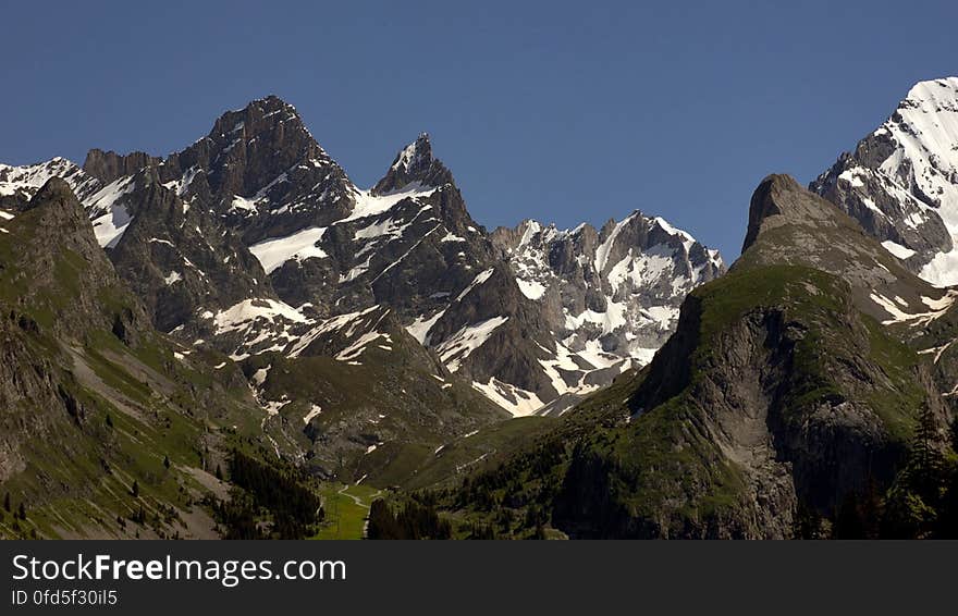 Rocky Mountains Covered With Green Grass and Snow