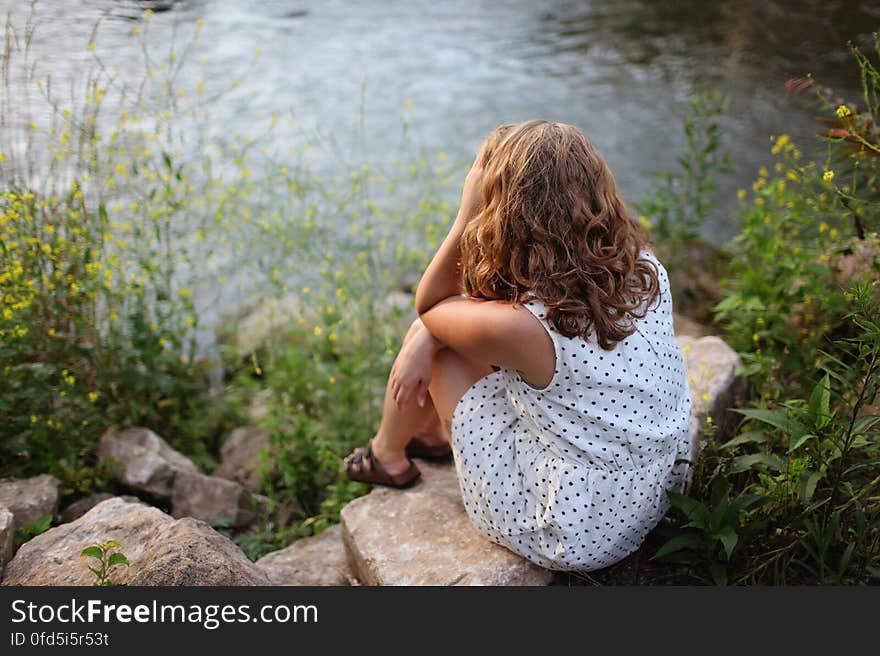 Woman Sitting by Lake