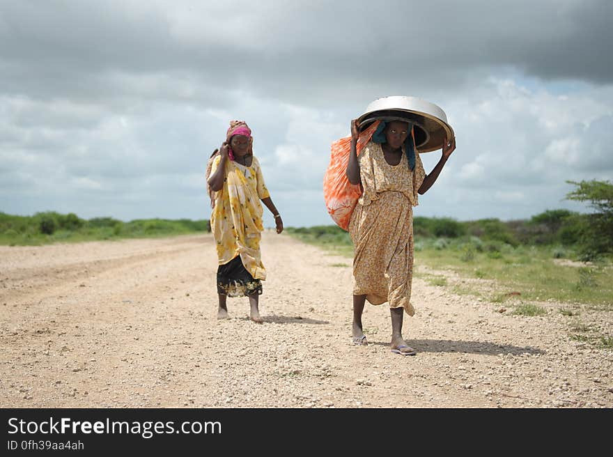 Women, walking with what possesions they can carry, arrive in a steady trickle at an IDP camp erected next to an AMISOM military base near the town of Jowhar, Somalia, on November 12. Heavy rains in Somalia, coupled with recent disputes between clans, has resulted in over four thousand IDPs seeking shelter at an AMISOM military base near the town of Jowhar, with more arriving daily. AU UN IST Photo / Tobin Jones. Women, walking with what possesions they can carry, arrive in a steady trickle at an IDP camp erected next to an AMISOM military base near the town of Jowhar, Somalia, on November 12. Heavy rains in Somalia, coupled with recent disputes between clans, has resulted in over four thousand IDPs seeking shelter at an AMISOM military base near the town of Jowhar, with more arriving daily. AU UN IST Photo / Tobin Jones