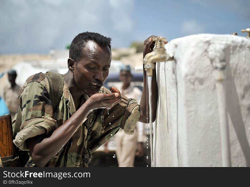 A member of the Somali National Army drinks from a newly opened well donated by the African Union Mission in Somalia to a local community in the country&#x27;s capital of Mogadishu on June 6. AMISOM Photo / Tobin Jones. A member of the Somali National Army drinks from a newly opened well donated by the African Union Mission in Somalia to a local community in the country&#x27;s capital of Mogadishu on June 6. AMISOM Photo / Tobin Jones