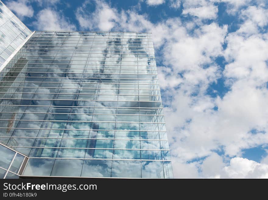 Bottom View of Clear Glass Building Under Blue Cloudy Sky during Day Time