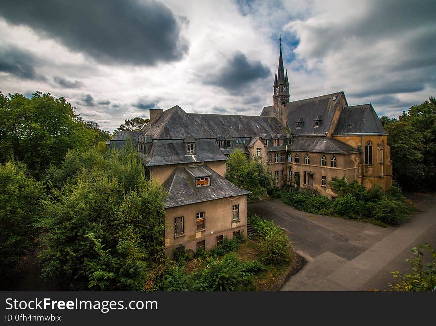 3 Storey Mansion Near Trees Under Cloudy Sky