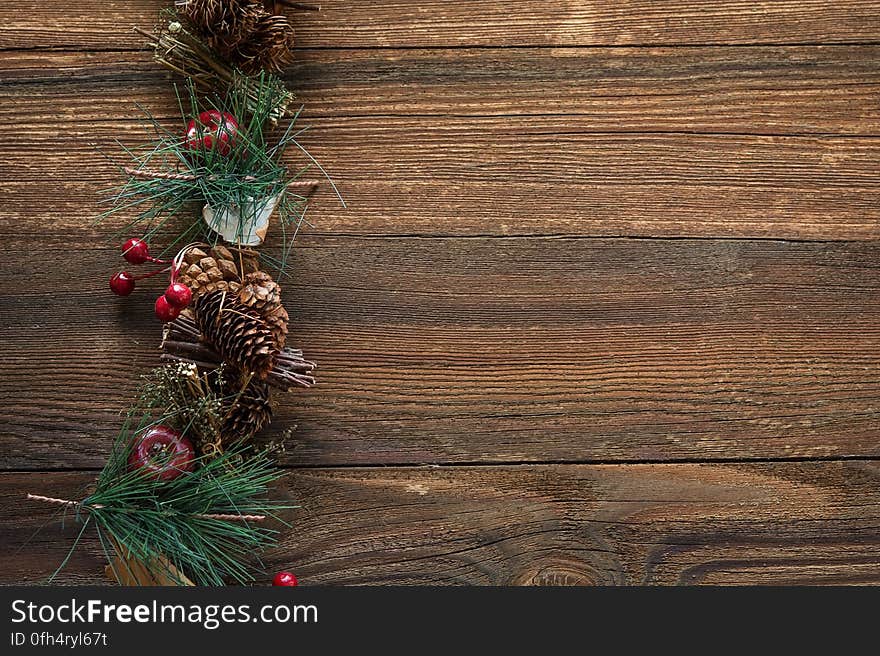 A christmas background with conifer branches and cones on wooden background.