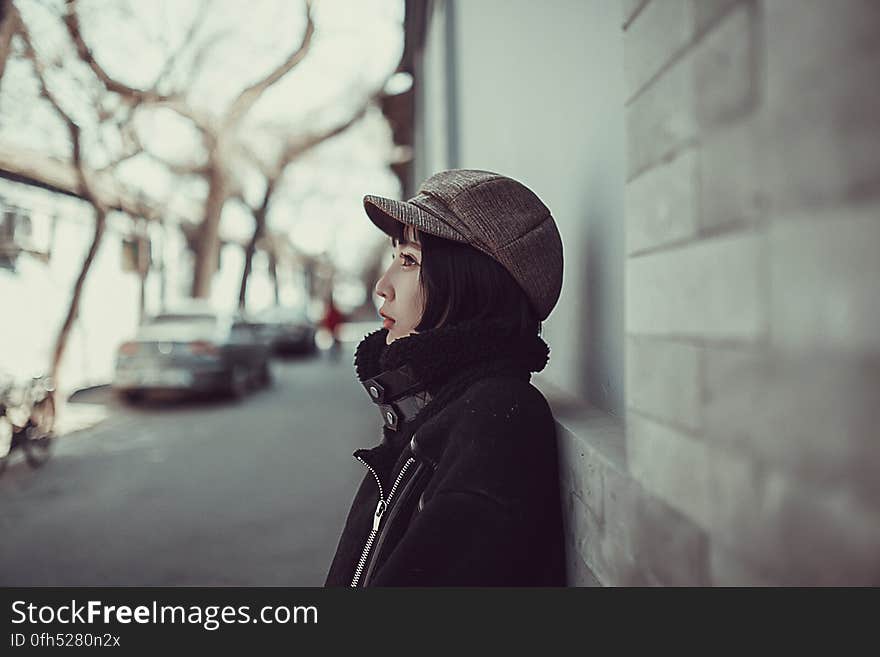 Attractive young woman in urban environment posing in zipped jacket, scarf and fashionable peak cap. Attractive young woman in urban environment posing in zipped jacket, scarf and fashionable peak cap.