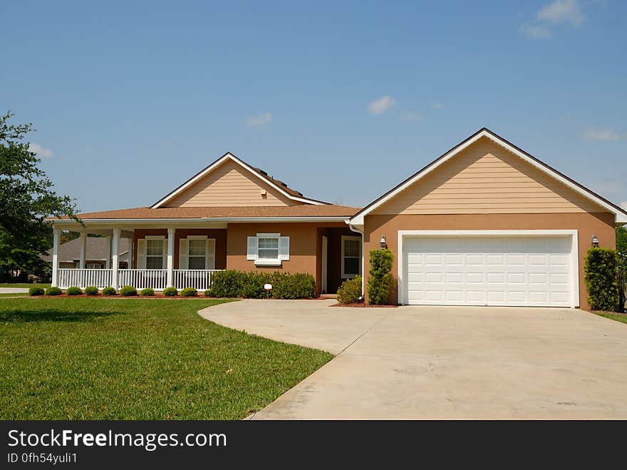 Modern bungalow with covered front porch with decking and balustrade with front manicured lawn and on the right a large double garage with smart driveway. Modern bungalow with covered front porch with decking and balustrade with front manicured lawn and on the right a large double garage with smart driveway.