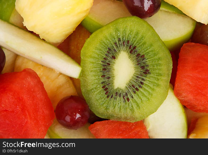 A fruit salad with apple, melon, grapes and kiwi.