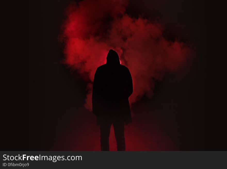 Silhouette of Man Standing Against Black And Red Background