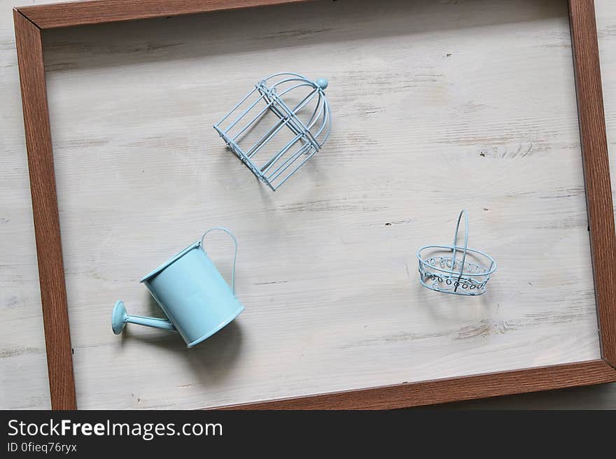 Blue colored toy gardening tools filling a wooden frame on a wooden background. Blue colored toy gardening tools filling a wooden frame on a wooden background