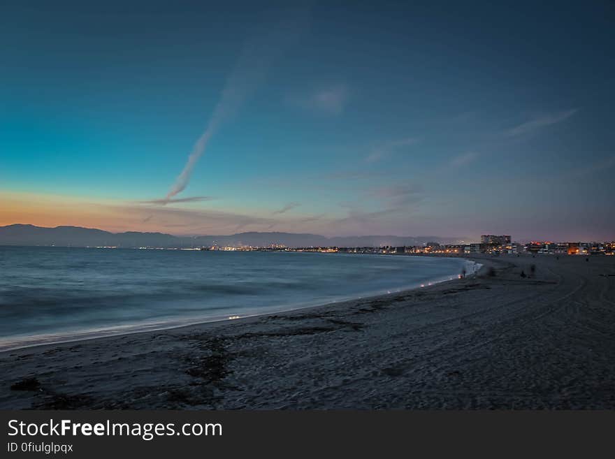 People on Beach&#x27;s Seashore during Sunset