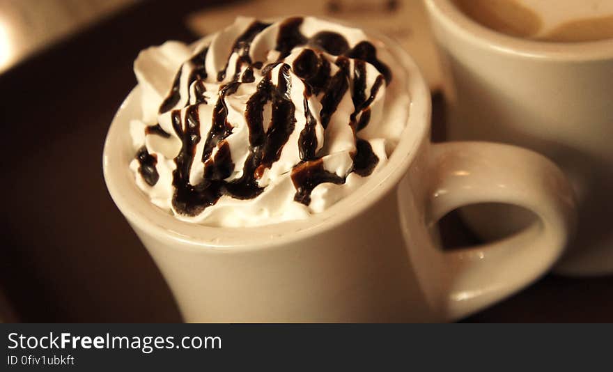 A close up of a cup of hot chocolate with whipped cream on top.