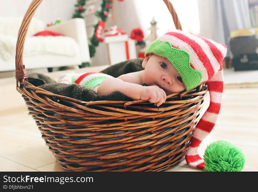 Cute baby in Christmas hat playing in wicker basket. Cute baby in Christmas hat playing in wicker basket.