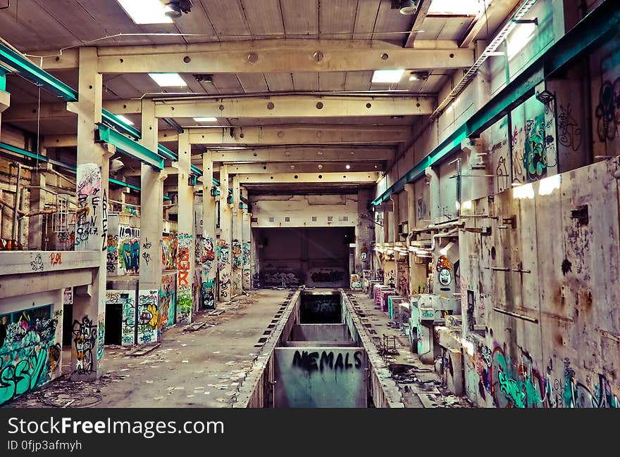 Interior of abandoned factory with colorful graffiti.