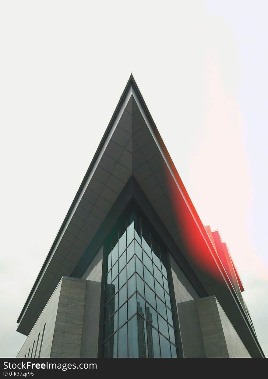 Angled roof on modern building against sunny sky.