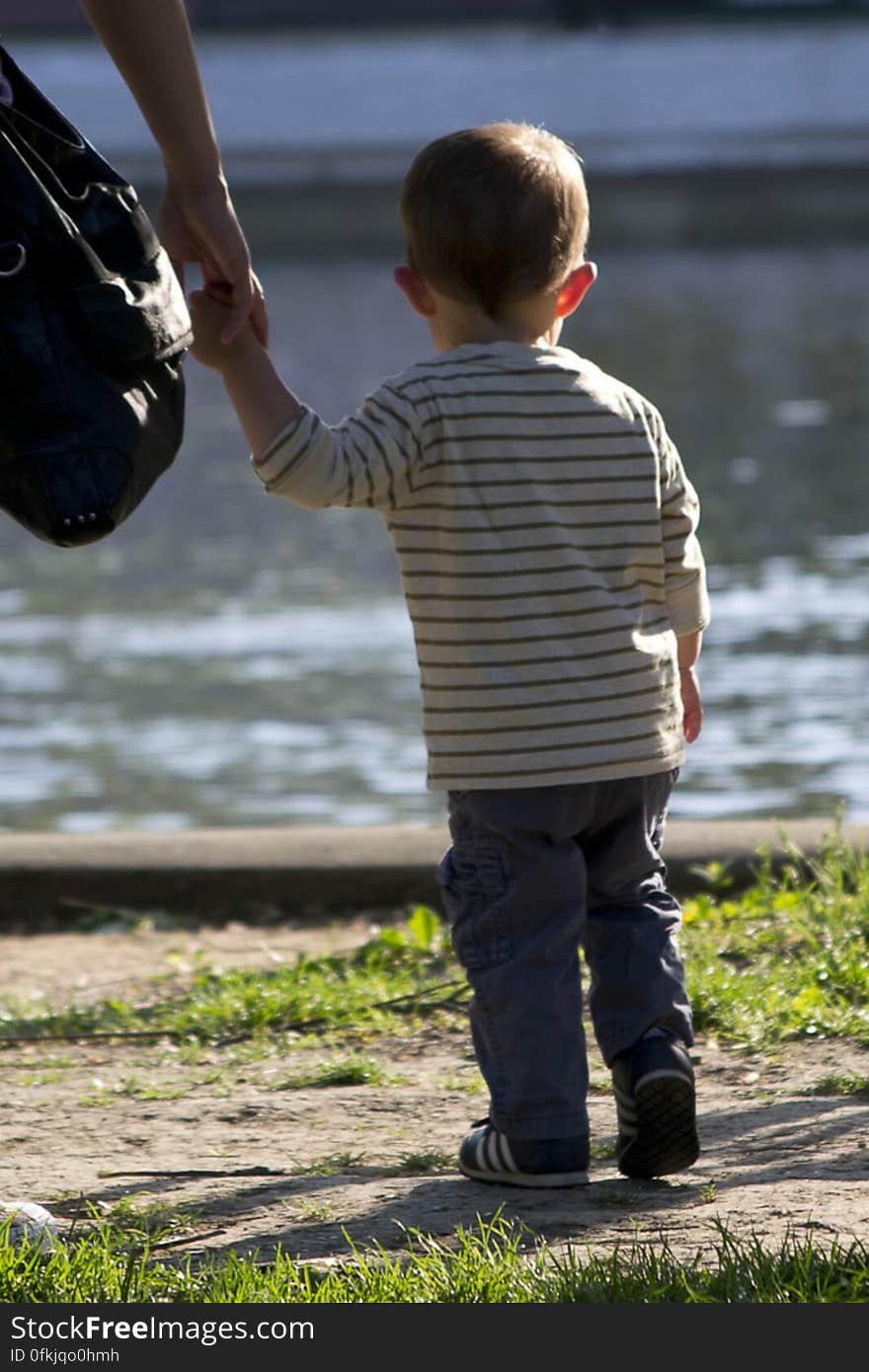 Mother and kid by lake in a park. Mother and kid by lake in a park