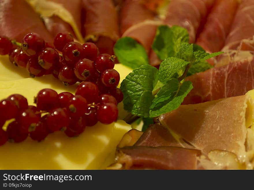 Plate of cold cuts and cheese decorated with mint and cranberries. Plate of cold cuts and cheese decorated with mint and cranberries.