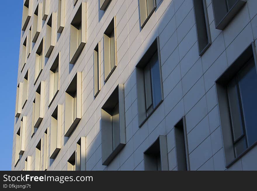 Irregular punched windows with aluminum frames on office building wall. Irregular punched windows with aluminum frames on office building wall.