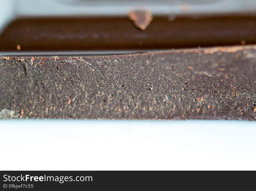 Dark chocolate with 70% cocoa butter. A macro shot of a broken chocolate tablet. Dark chocolate with 70% cocoa butter. A macro shot of a broken chocolate tablet.