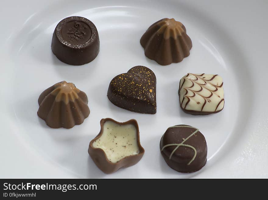 Picture of assorted swiss chocolate bonbons isolated on white plate.