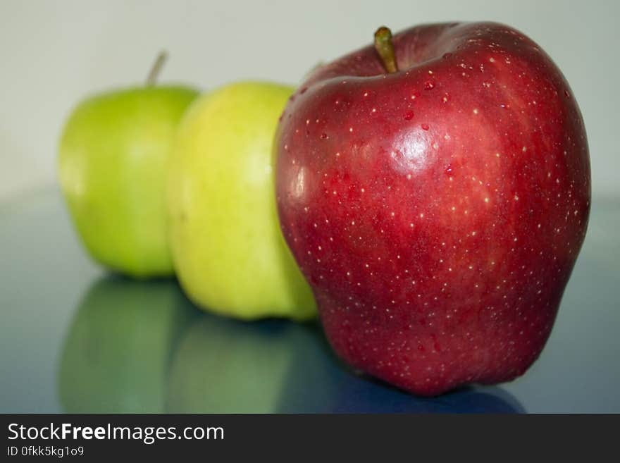 green-and-red-apples-reflection-on-glass