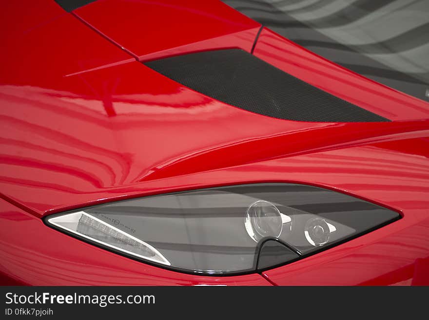 Photo of headlamp and hood of a fast Lotus Evora sportscar.