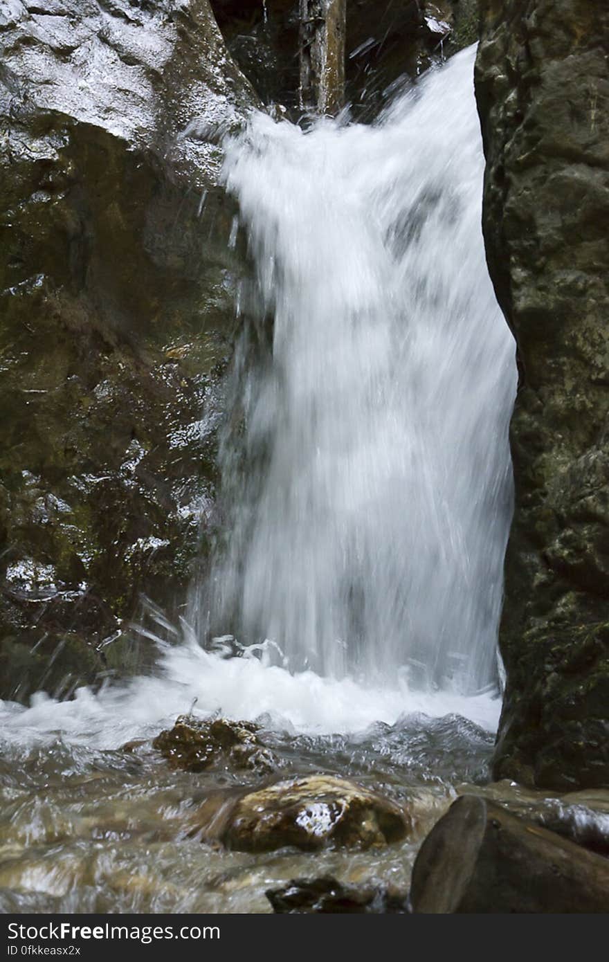 Forest waterfall blurred in slow motion capture.