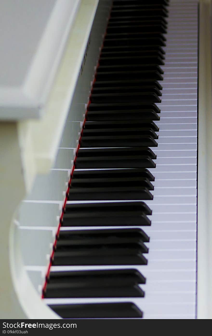 Ivory colored piano with open lid exposing keys. Ivory colored piano with open lid exposing keys