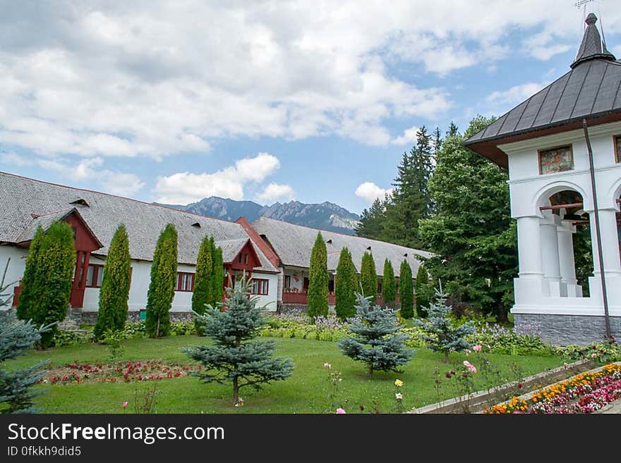 Monastery yard and garden with mountains in the distant background.