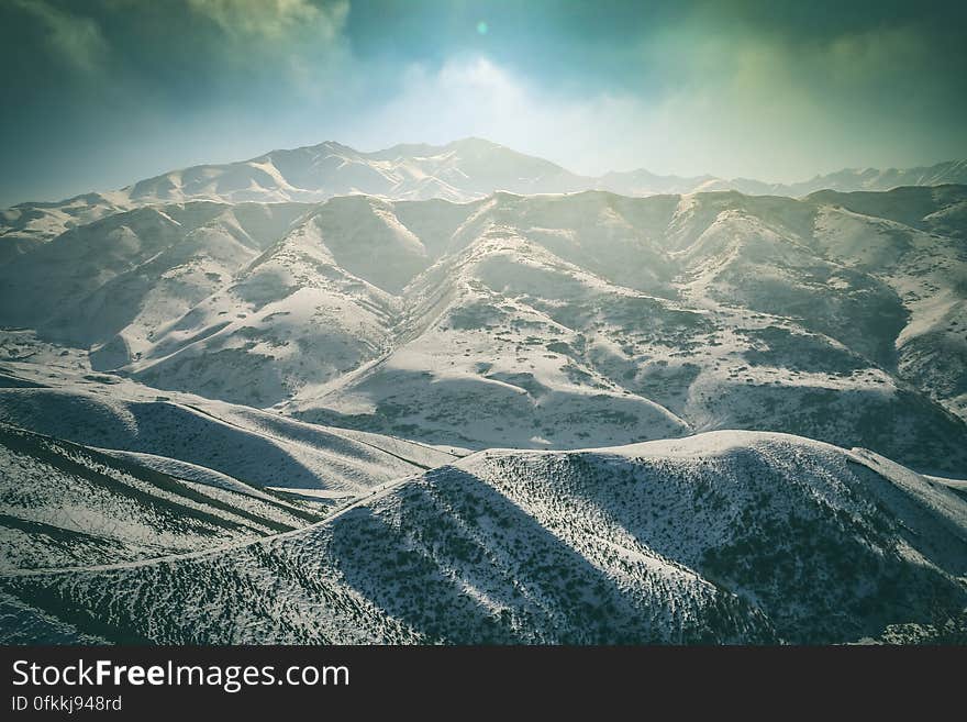 Background of frozen forests and snow covered mountains with threat from clouds of further snow falls. Background of frozen forests and snow covered mountains with threat from clouds of further snow falls.