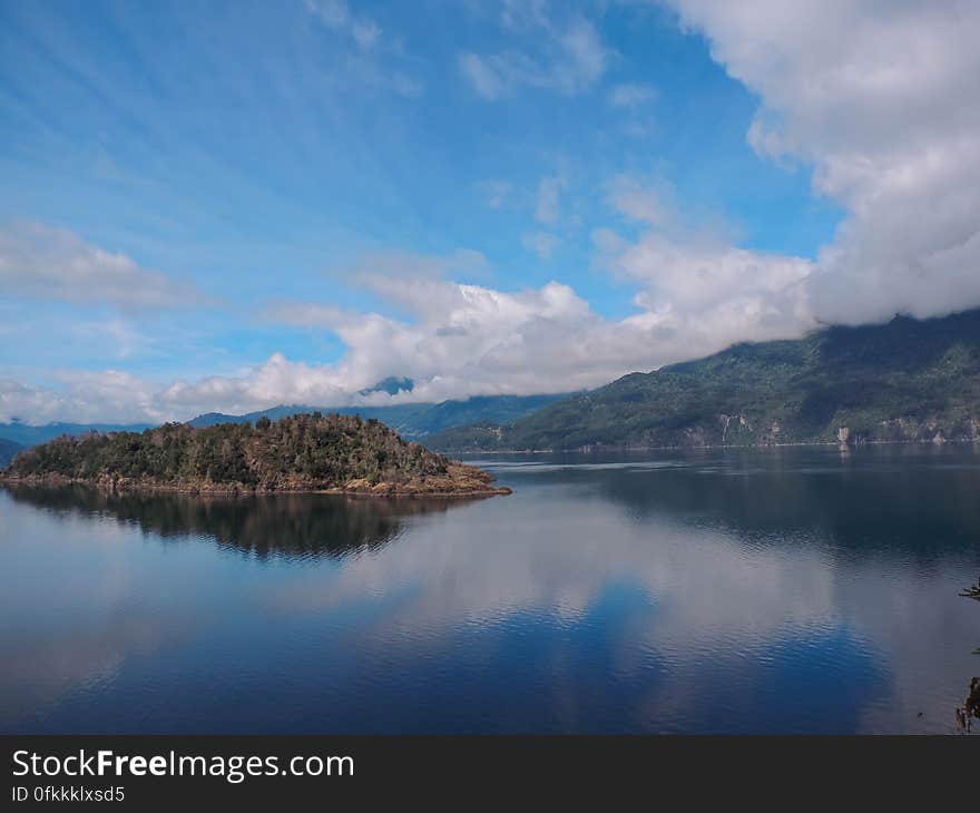 A calm lake with an island in the middle. A calm lake with an island in the middle.