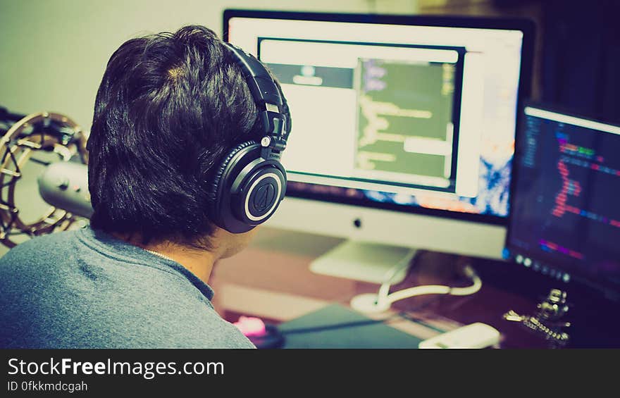 A man working on a computer wearing headset. A man working on a computer wearing headset.