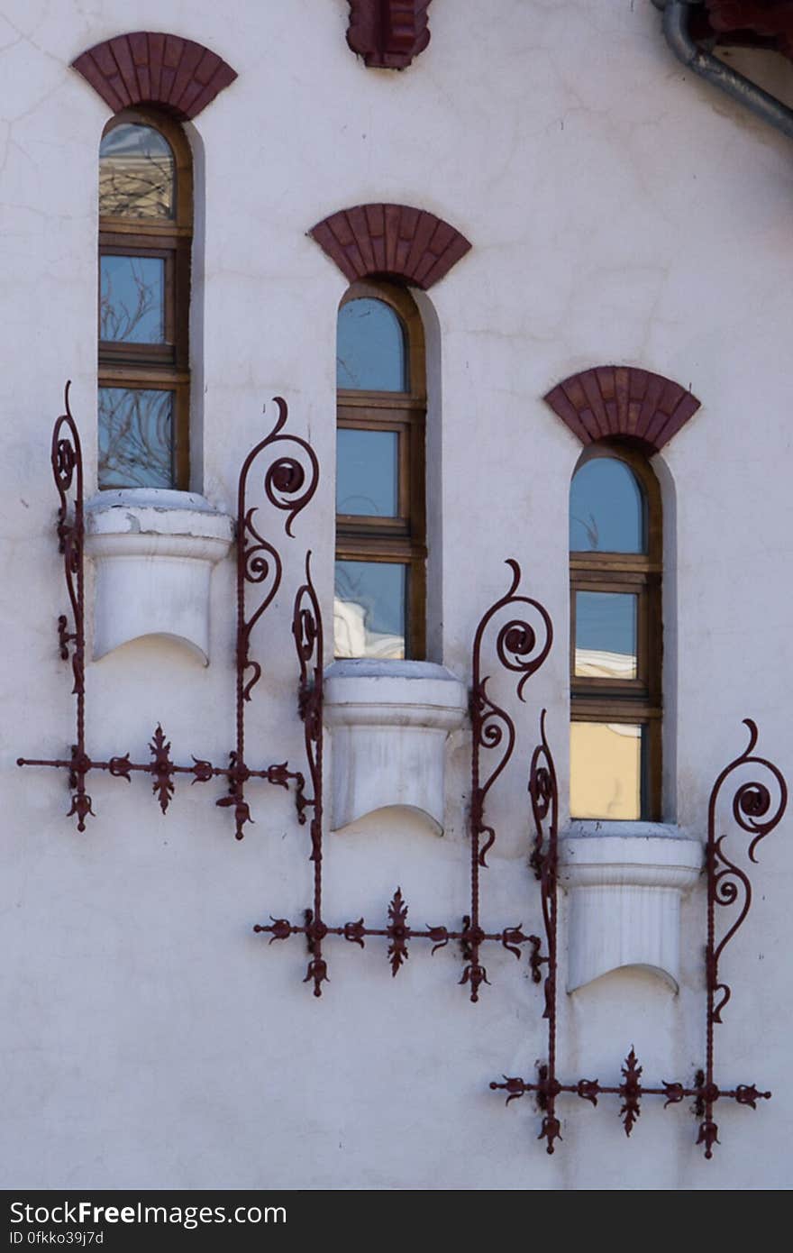 Image of a white villa facade with descending narrow windows.