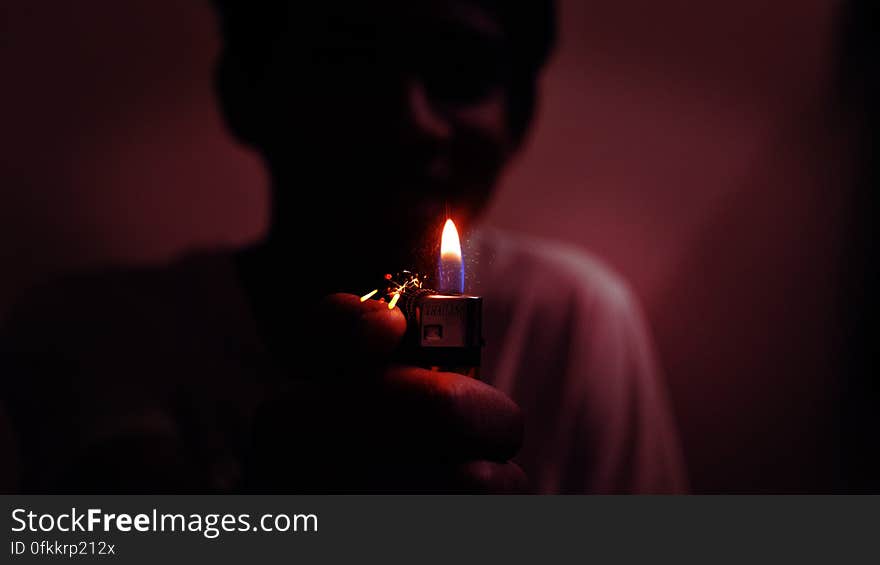 Boy (person) in dark room carrying a lighted candle to see their way. Boy (person) in dark room carrying a lighted candle to see their way.