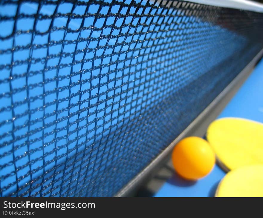 table-tennis-ball-and-racket-against-net