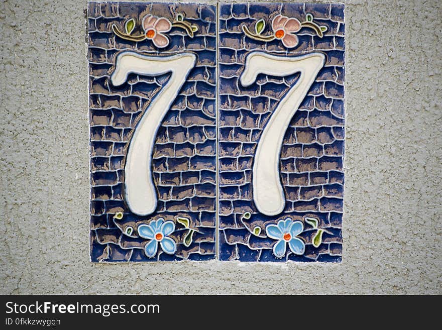 Picture of a ceramic house numbering plate with floral motifs.