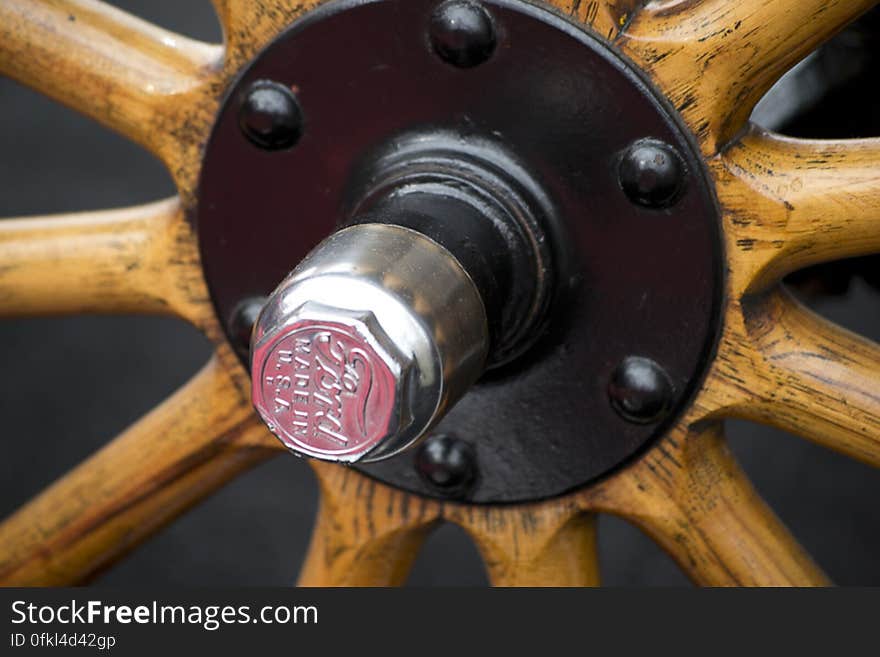 Picture of cap and bolts on wheel of a Ford Model T. Wooden spokes were used, soon to be replaced by steel ones.