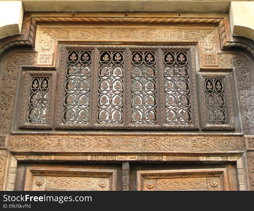 wrought-iron-ornamentation-above-carved-wooden-door