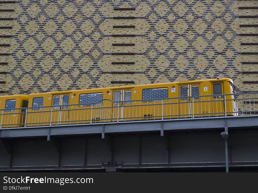 Yellow train passing on elevated railway which minimizes traffic problems inside a city. Yellow train passing on elevated railway which minimizes traffic problems inside a city.