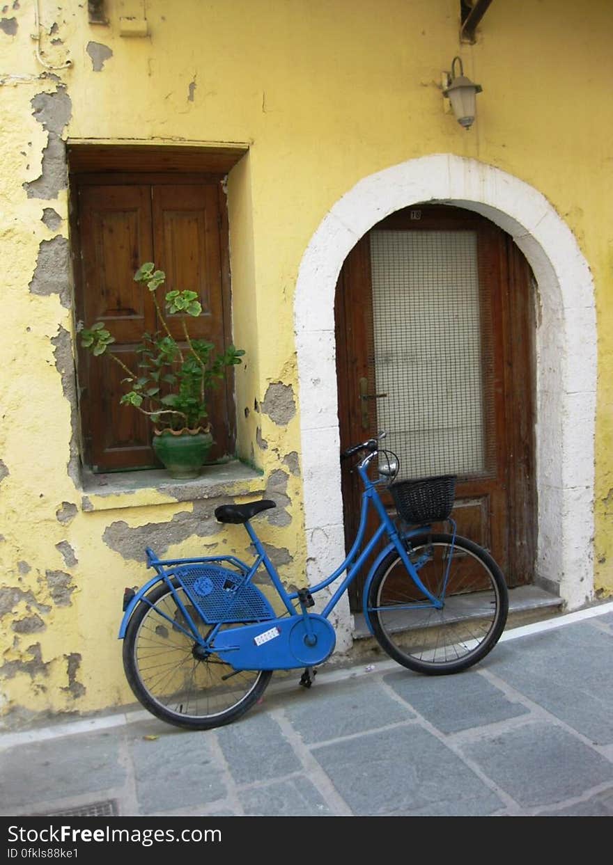 blue-bicycle-leaning-on-wall