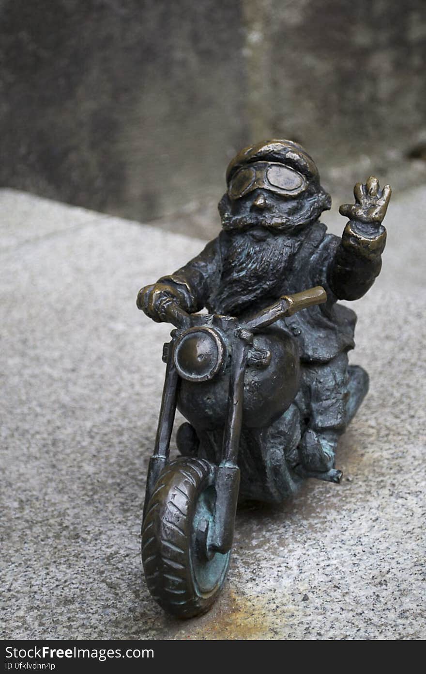 Dwarf riding motorcycle and waving at the camera. Dwarf riding motorcycle and waving at the camera.