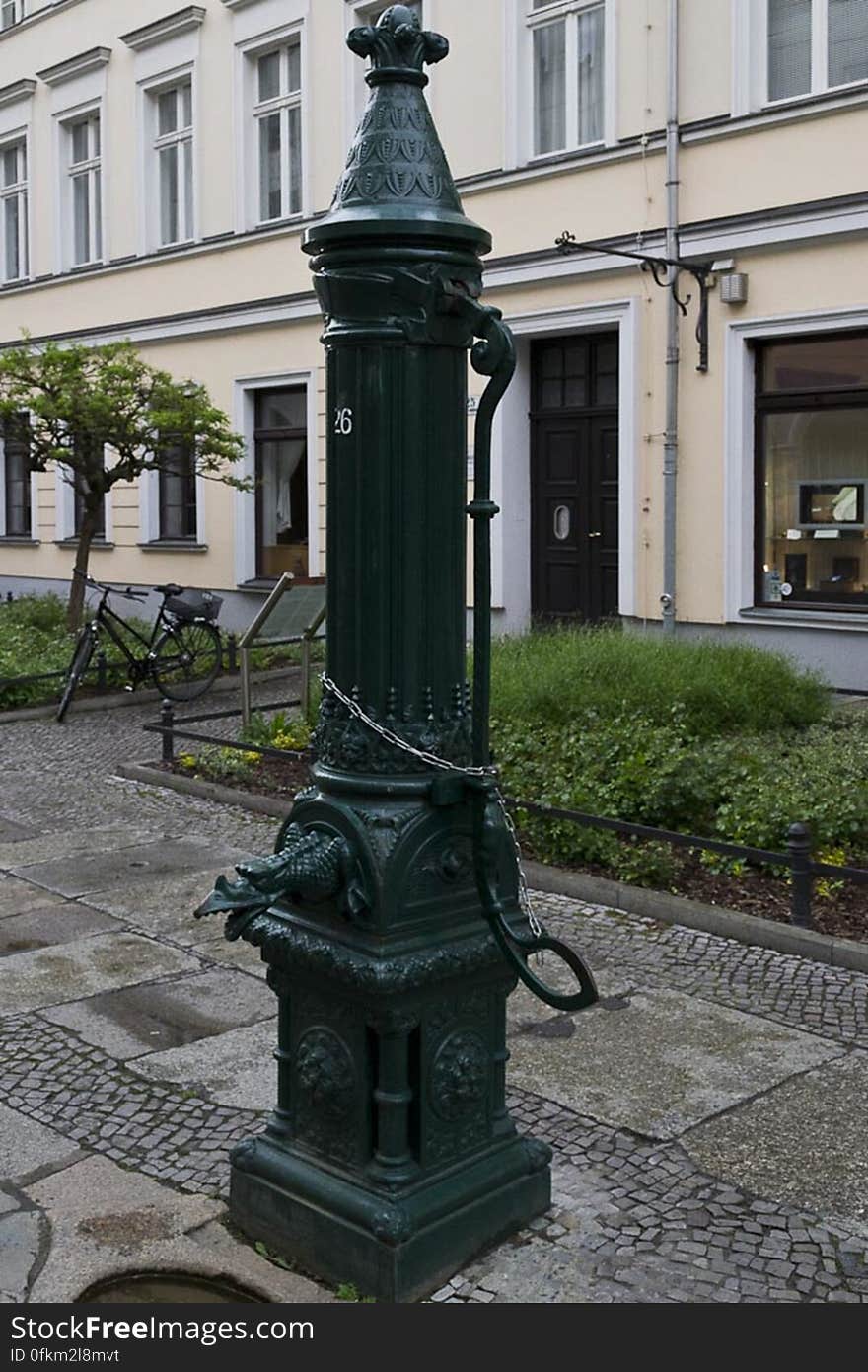 Manual water pump decorated with a dragon&#039;s head in Berlin&#039;s old quarter Nikolaiviertel.